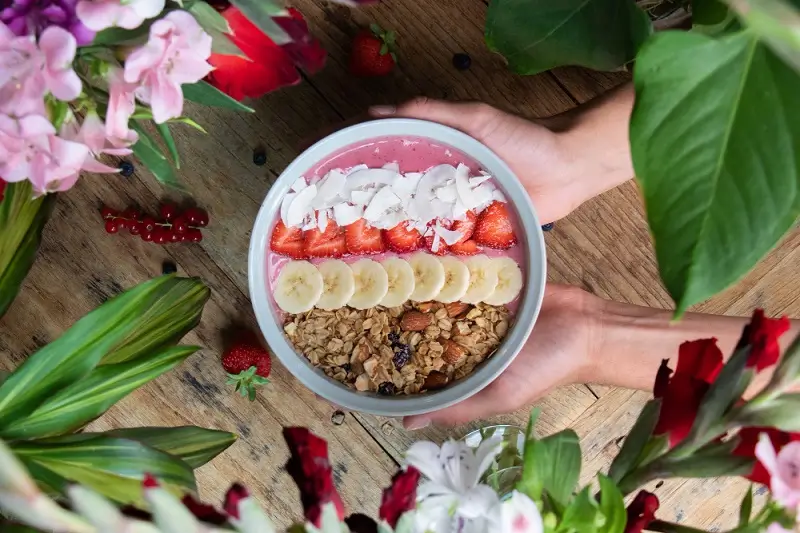 Breakfast smoothie bowl with banana, strawberry, coconut and granola