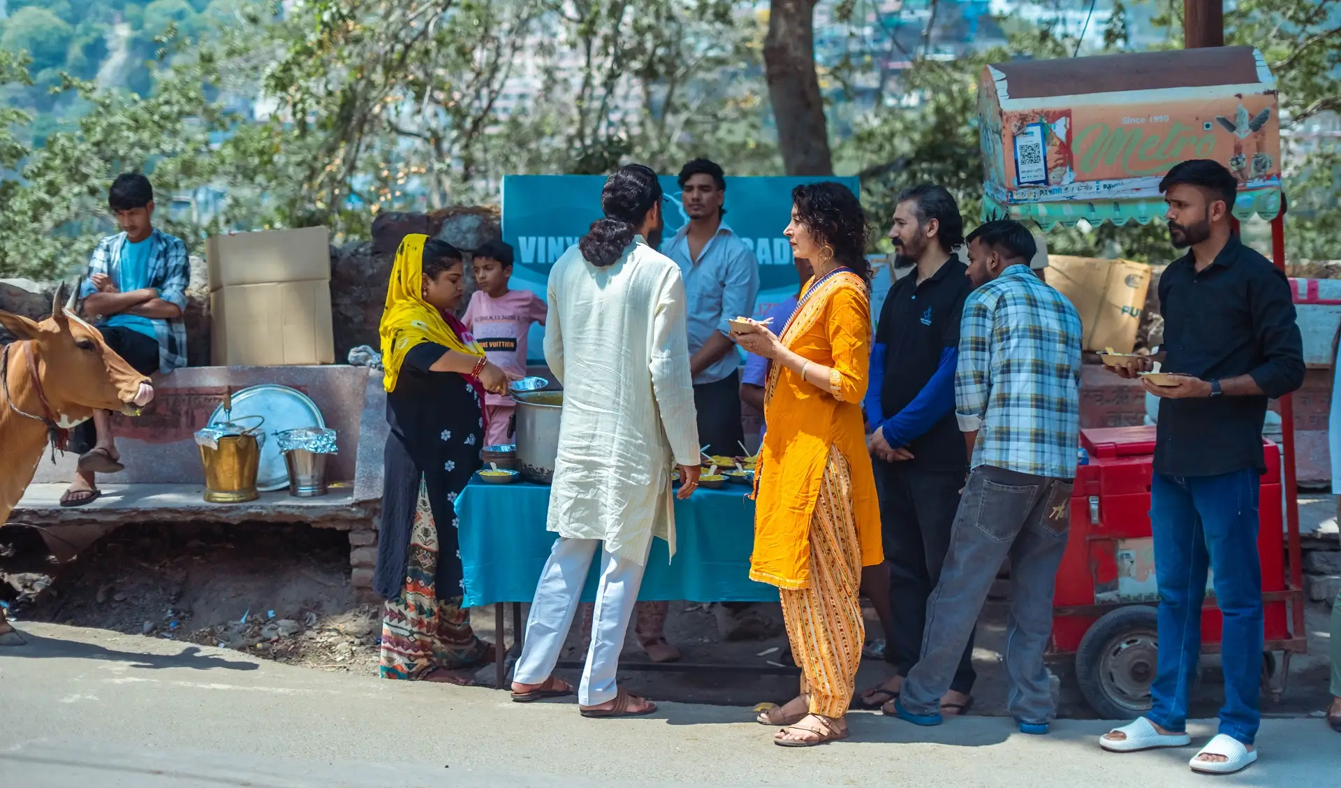 Trainees and teachers serving bowls of hot food at the roadside stall in Rishikesh
